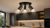 Modern kitchen featuring a black three-bulb track light fixture illuminating a marble countertop and dark cabinetry.